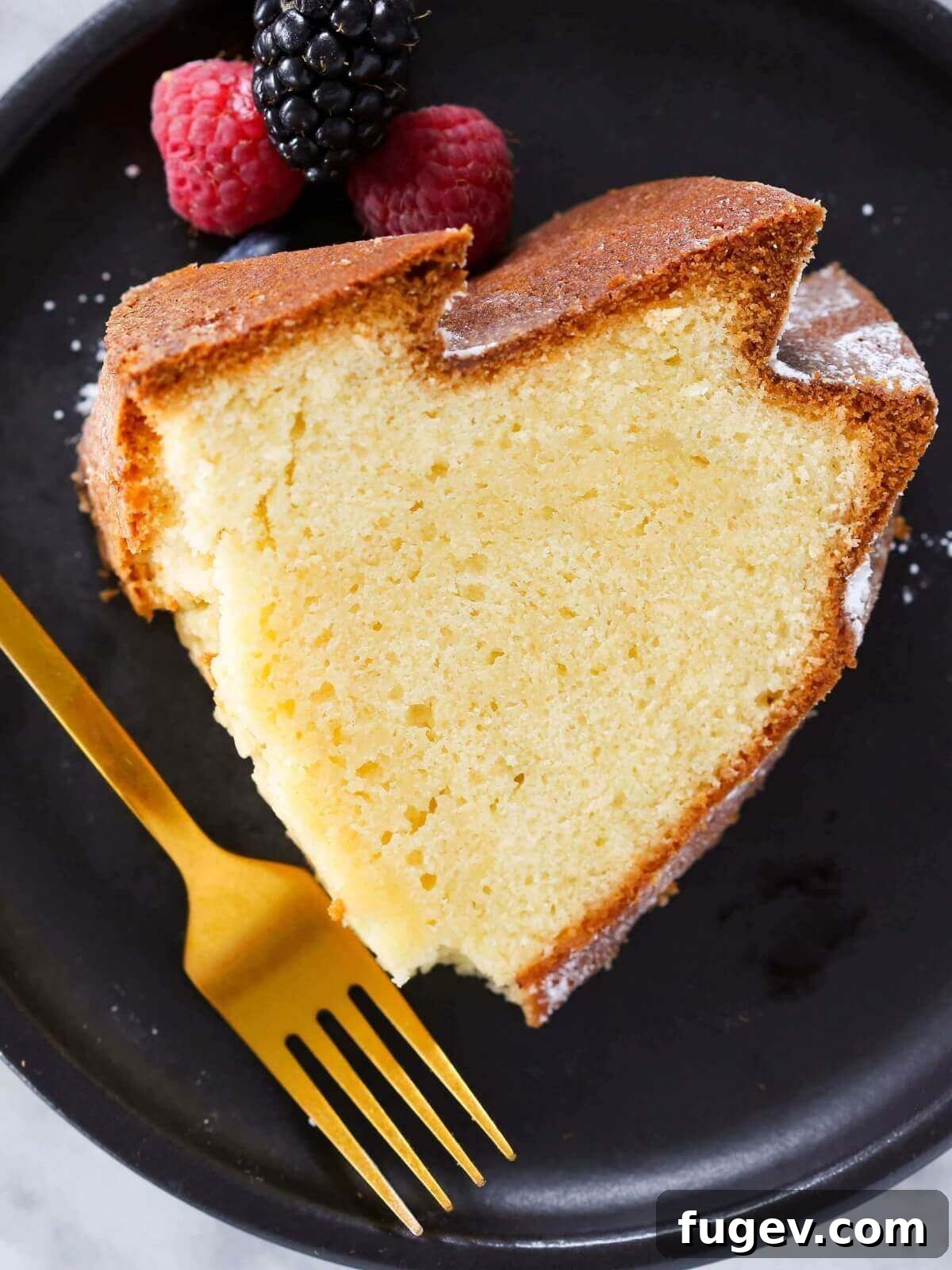 Velvet Sour Cream Pound Cake 2 A slice of perfect Sour Cream Pound Cake on a sleek black plate, showcasing its dense and moist texture.