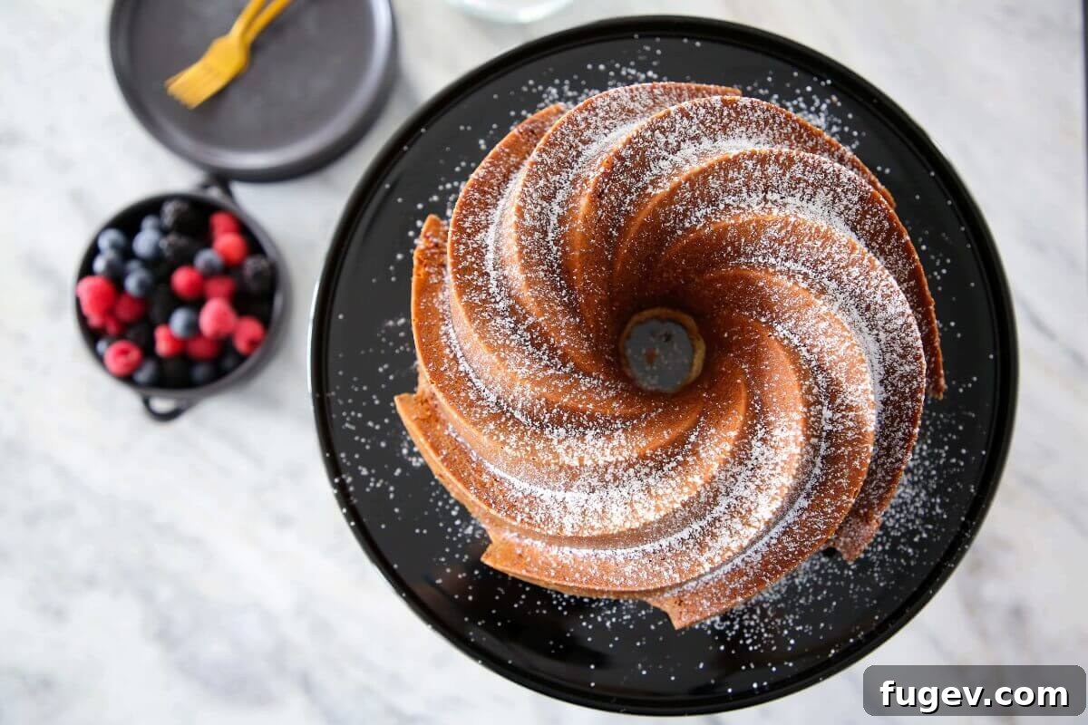 Velvet Sour Cream Pound Cake 3 A beautifully sliced Sour Cream Pound Cake served with a vibrant bowl of fresh berries.