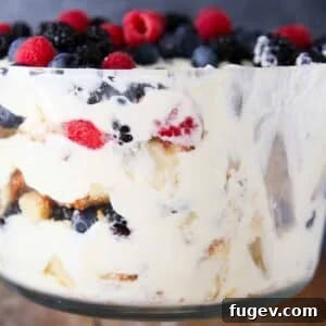 Side view of a berry trifle with lemon whipped cream, showing clear layers.