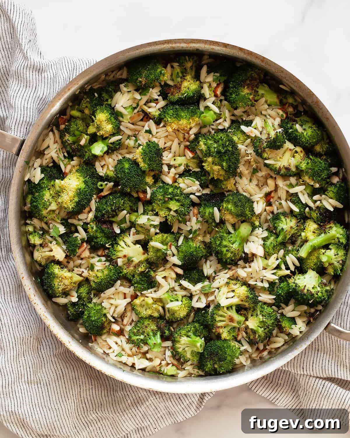Golden Roasted Broccoli Orzo 7 Close-up of Orzo with roasted broccoli, almonds, lemon, and garlic in a sauté pan.