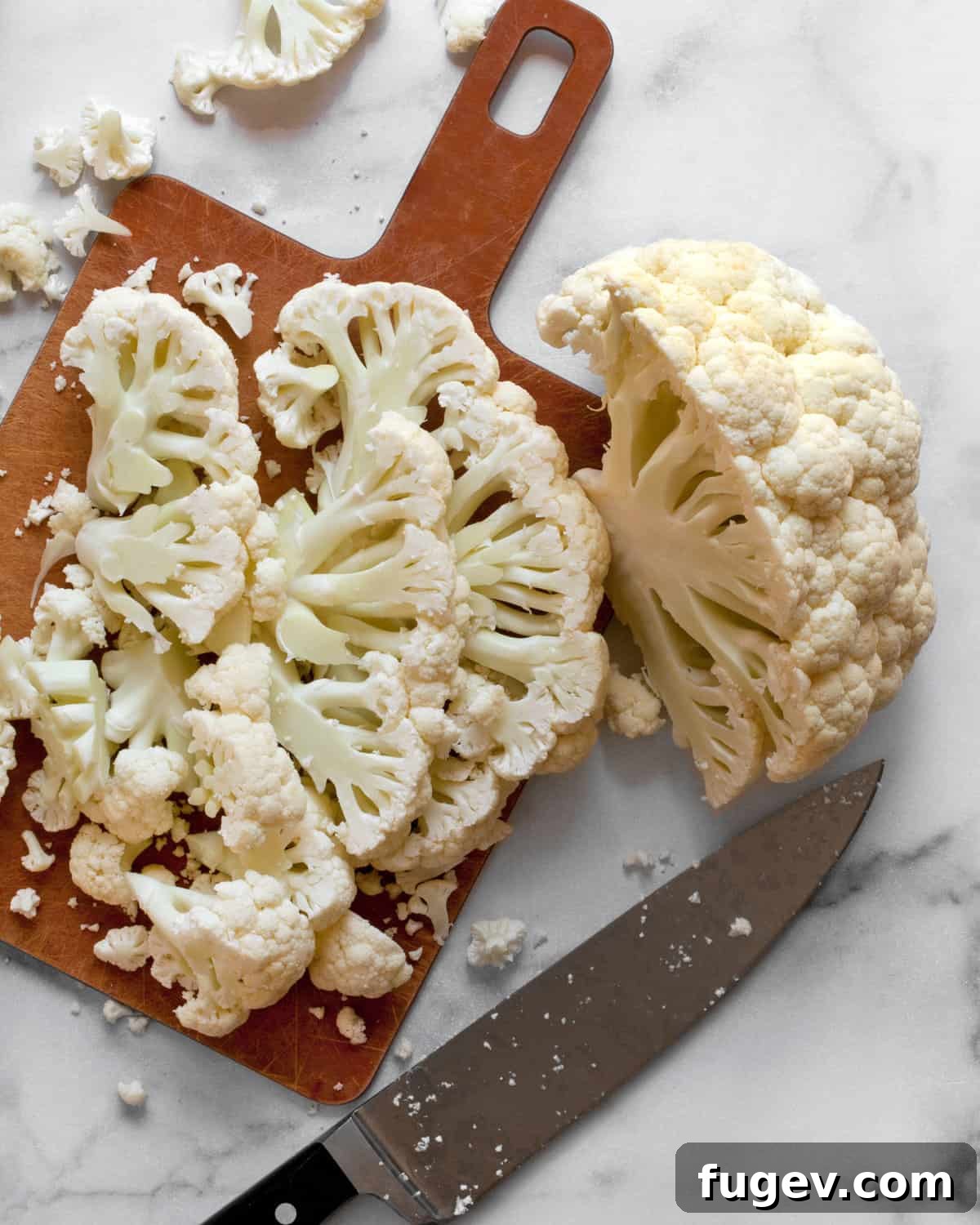 Caramelized Cauliflower Salad 4 A head of cauliflower neatly sliced into thick pieces on a wooden cutting board, ready for roasting.