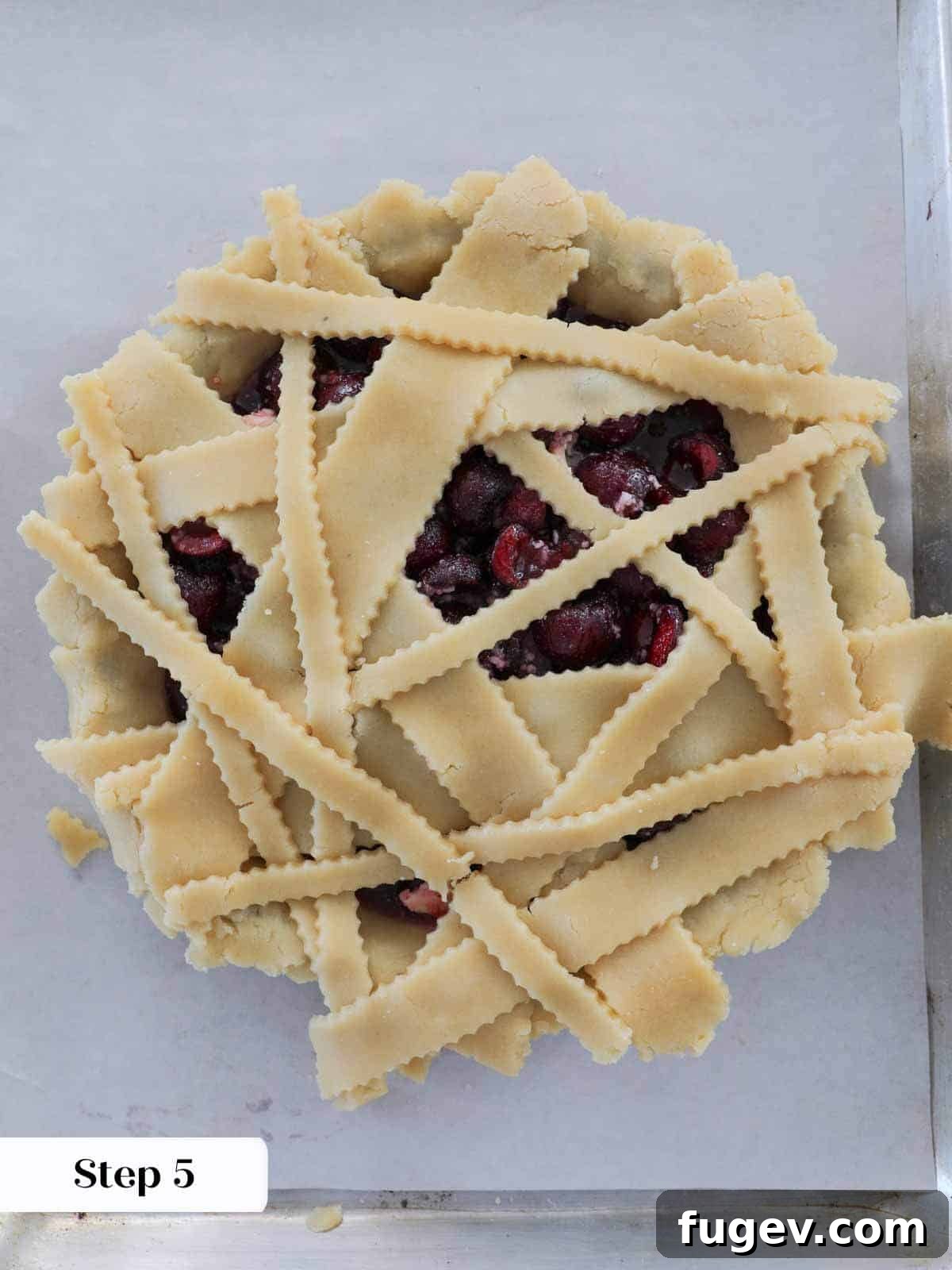 Crimson Delight 5 Unbaked cherry pie with untrimmed top crust laid over the filling, ready for finishing.