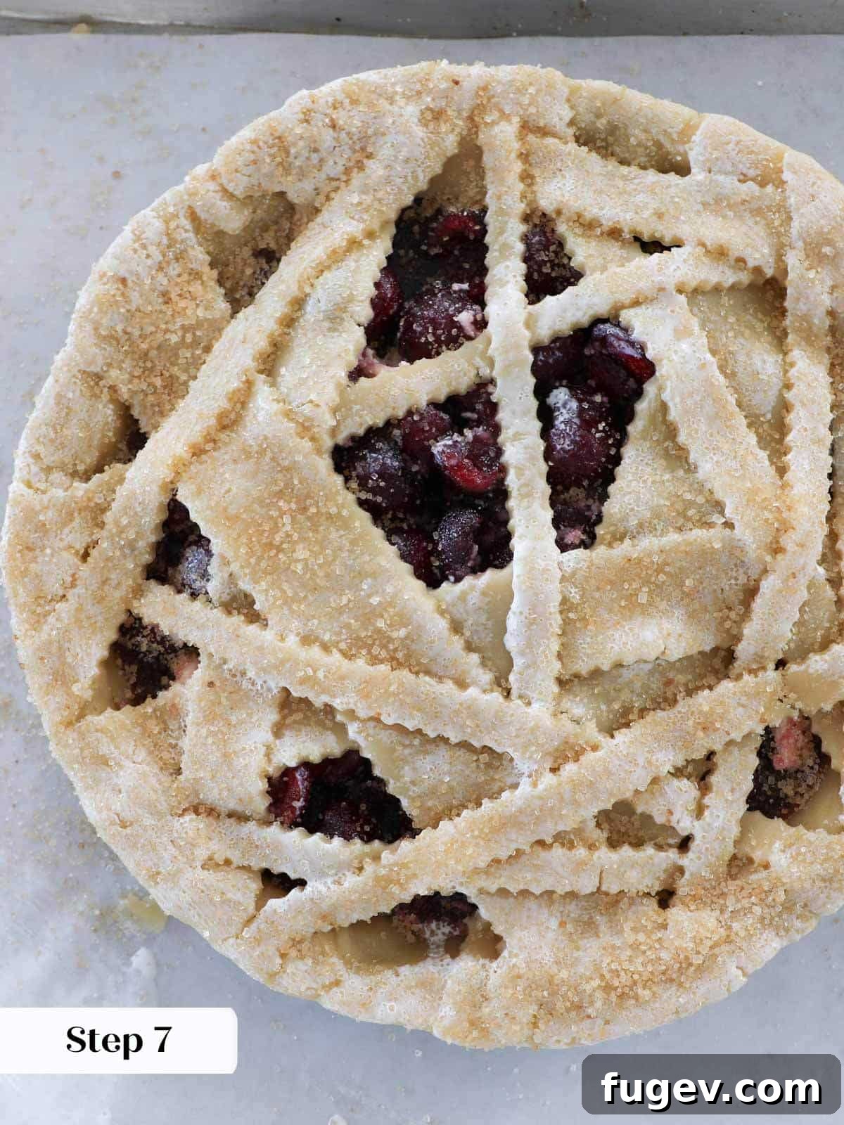 Crimson Delight 7 Unbaked cherry pie with a sugared top crust, ready to be placed in the oven.