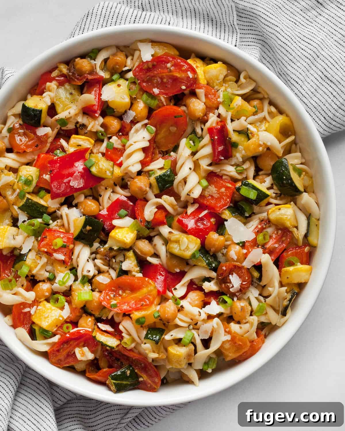 Mediterranean Roasted Vegetable & Chickpea Pasta 2 A vibrant bowl of roasted vegetable chickpea pasta salad, showcasing golden chickpeas and colorful vegetables.