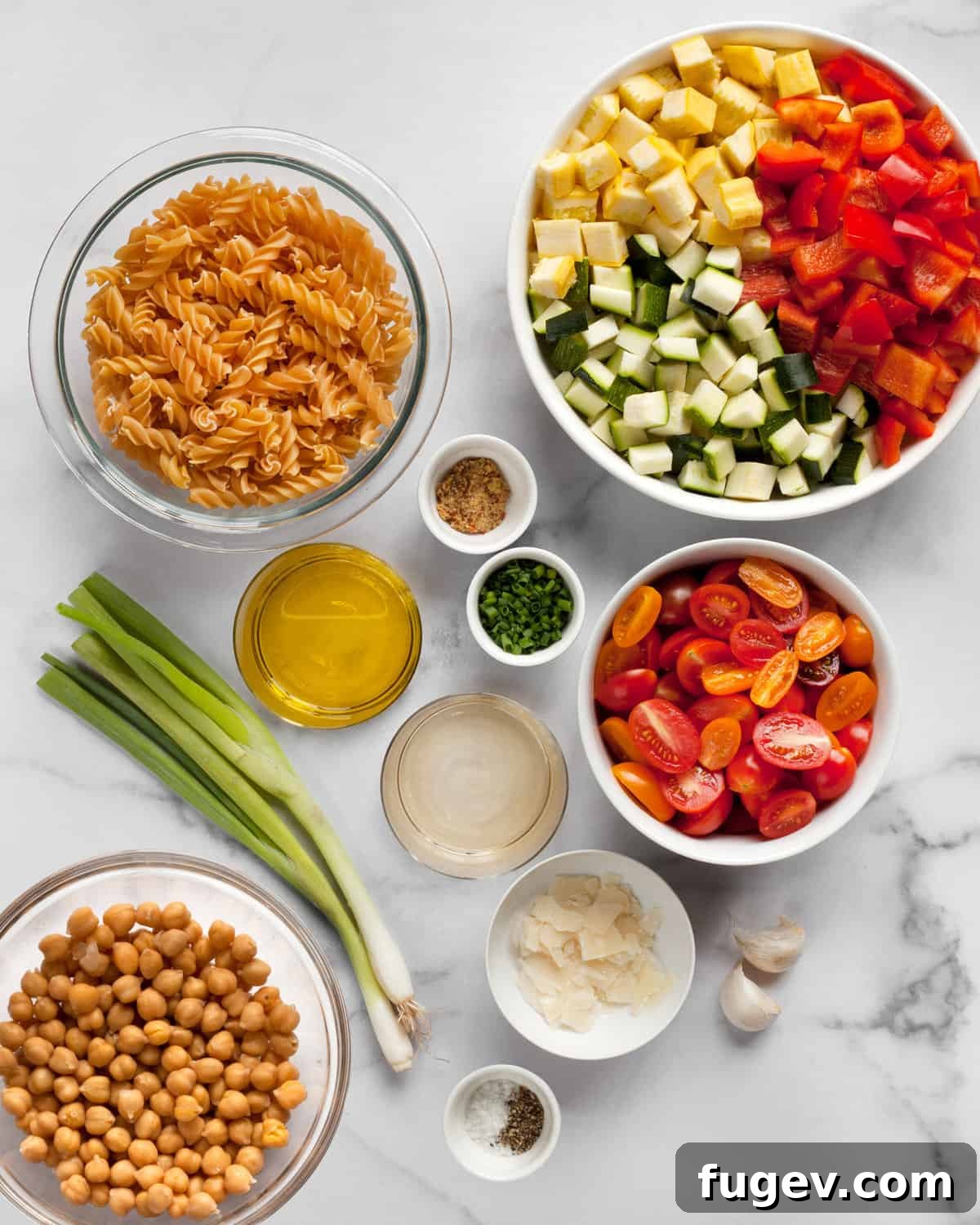 Mediterranean Roasted Vegetable & Chickpea Pasta 3 A flat lay of fresh ingredients: chickpea pasta, colorful vegetables, canned chickpeas, vinegar, olive oil, garlic, and scallions.