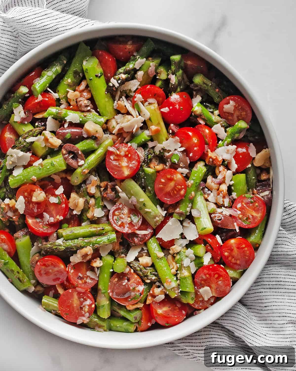 Mediterranean Grilled Asparagus Medley 2 A beautifully presented grilled asparagus salad, vibrant with tomatoes, olives, and parmesan, served in a rustic bowl.