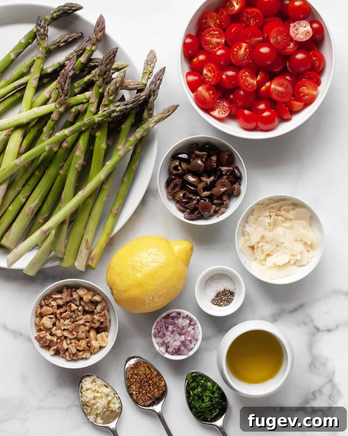 Mediterranean Grilled Asparagus Medley 3 An array of fresh ingredients for the grilled asparagus salad including green asparagus spears, red cherry tomatoes, dark olives, walnuts, parmesan shavings, parsley, garlic, mustard, olive oil, and lemons.