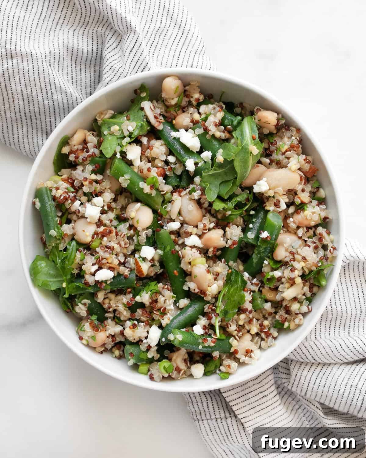 Green Bean Quinoa Bowl with White Beans and Toasted Almonds 7 A small, elegant bowl filled with Green Bean Quinoa with White Beans and Almonds, ready to be enjoyed.