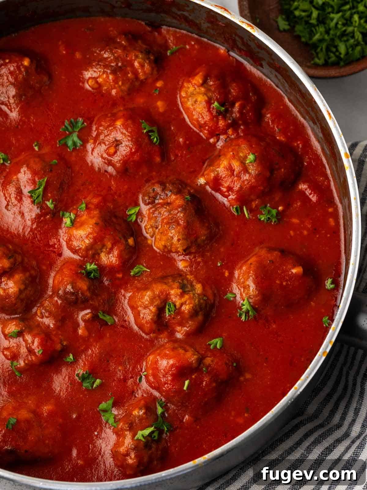 Cloud-Like Ricotta Meatballs 2 Tender ricotta meatballs simmering in a rich red sauce, garnished with fresh parsley.