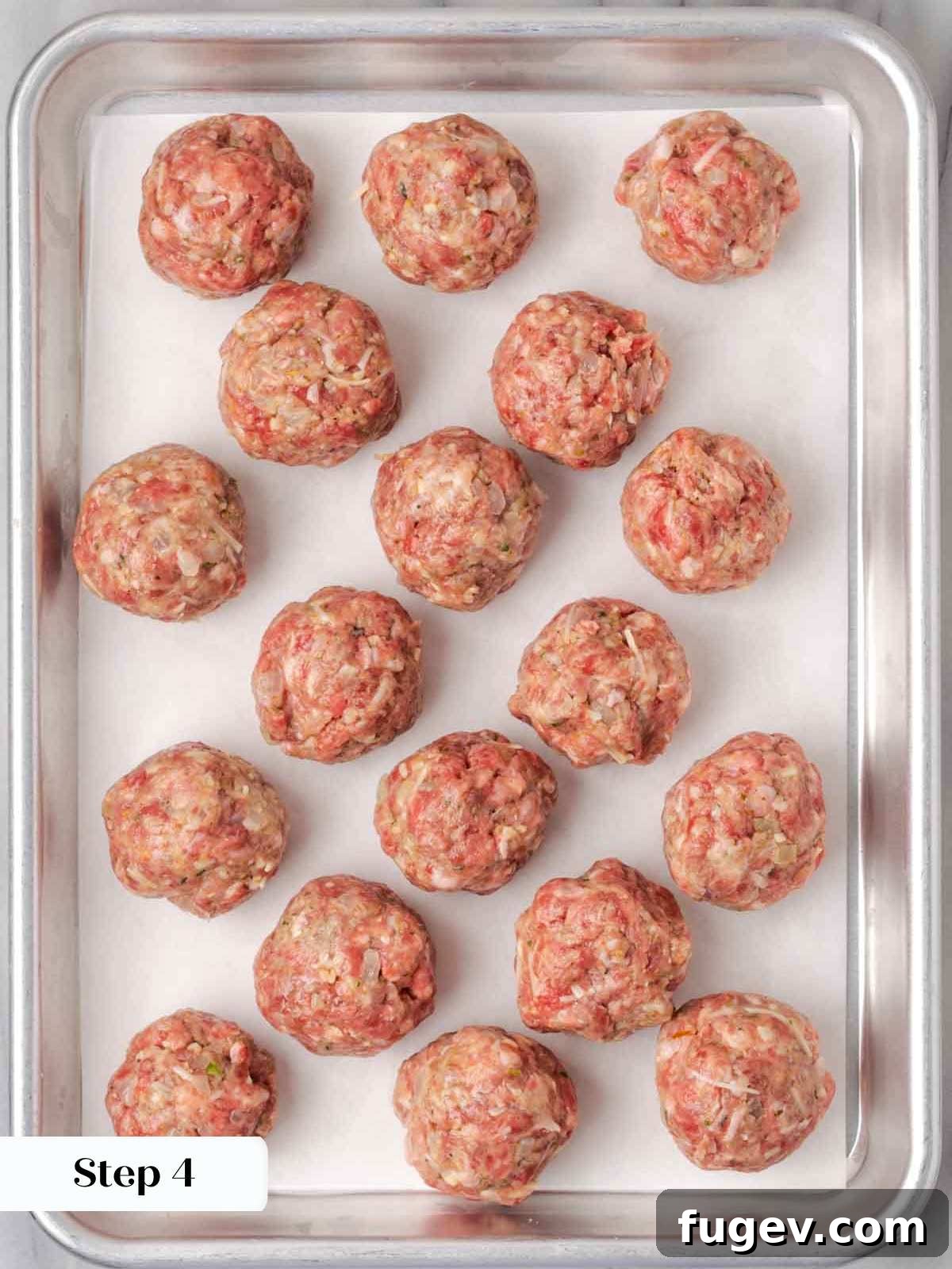 Cloud-Like Ricotta Meatballs 8 Perfectly rolled raw meatballs neatly arranged on a baking sheet, ready for chilling or searing.