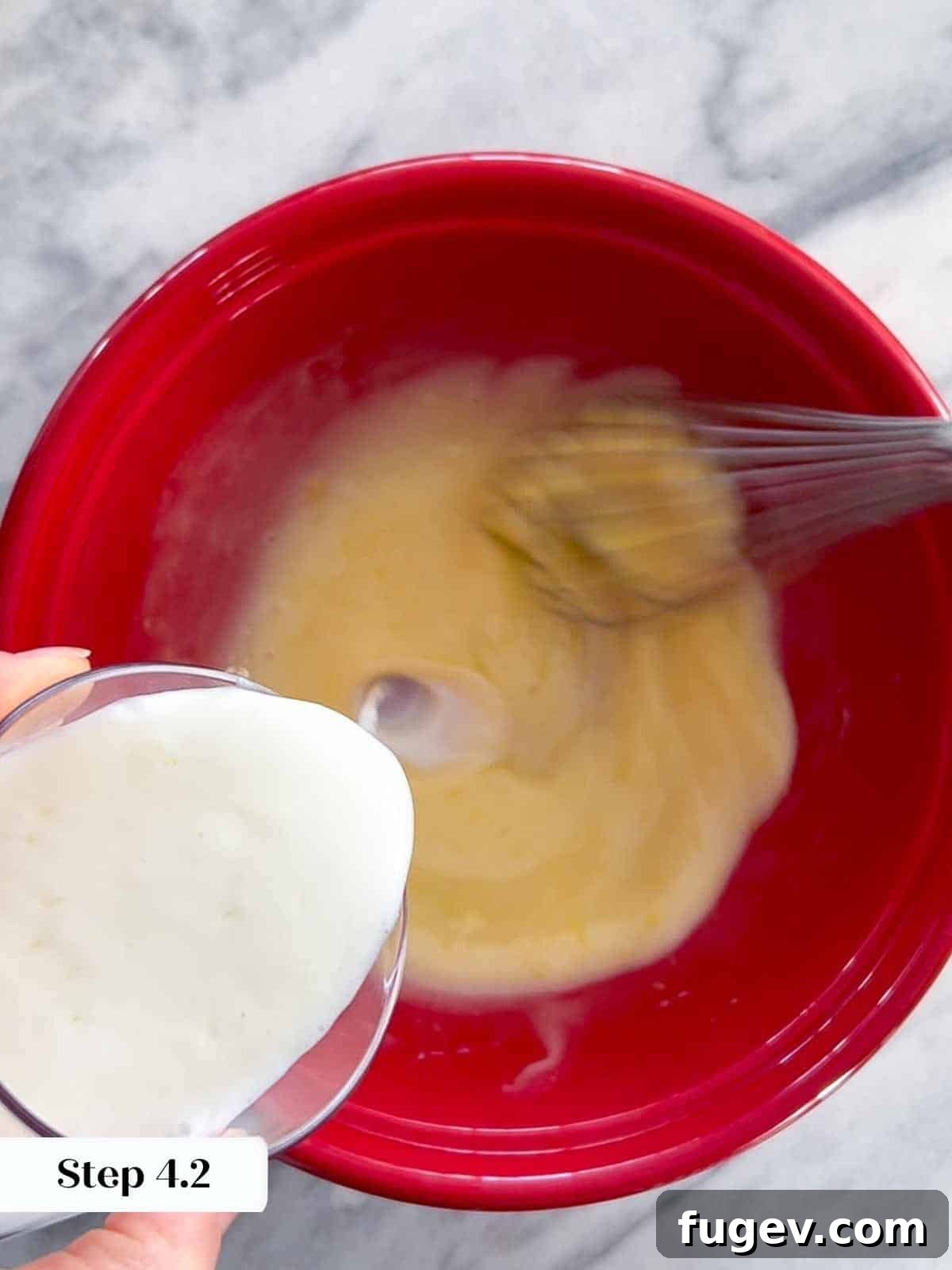 Homemade Strawberry Muffins 6 Buttermilk being poured into the pre-mixed wet ingredients (sugar, lemon zest, lemon juice, oil, and egg) for the strawberry muffin batter.