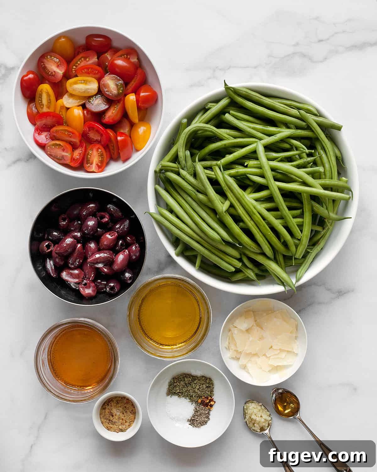 Sun-Kissed Green Bean and Olive Salad 3 A flat lay of fresh ingredients for the green bean salad, including green beans, tomatoes, olives, parmesan, red wine vinegar, mustard, garlic, and scallions.