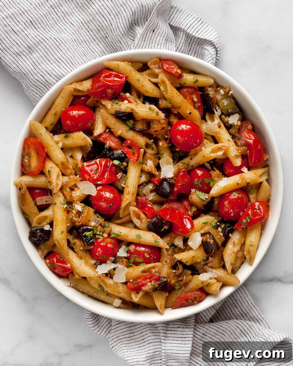 Roasted Eggplant and Burst Cherry Tomato Pasta 2 A beautifully presented bowl of spicy cherry tomato eggplant pasta, garnished with fresh herbs and shaved Parmesan.