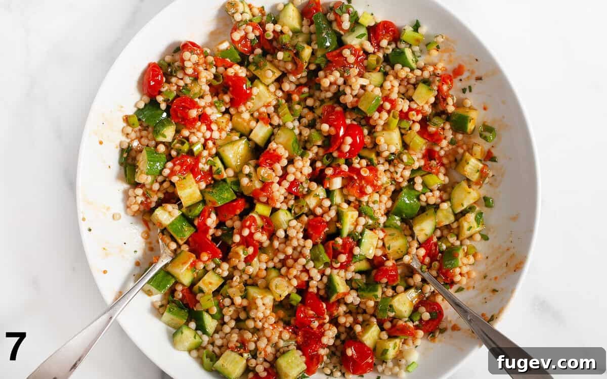Spicy Harissa Roasted Tomato Couscous 7 The finished Harissa Roasted Tomato Couscous in a bowl, with roasted tomatoes, cucumbers, and herbs perfectly tossed.