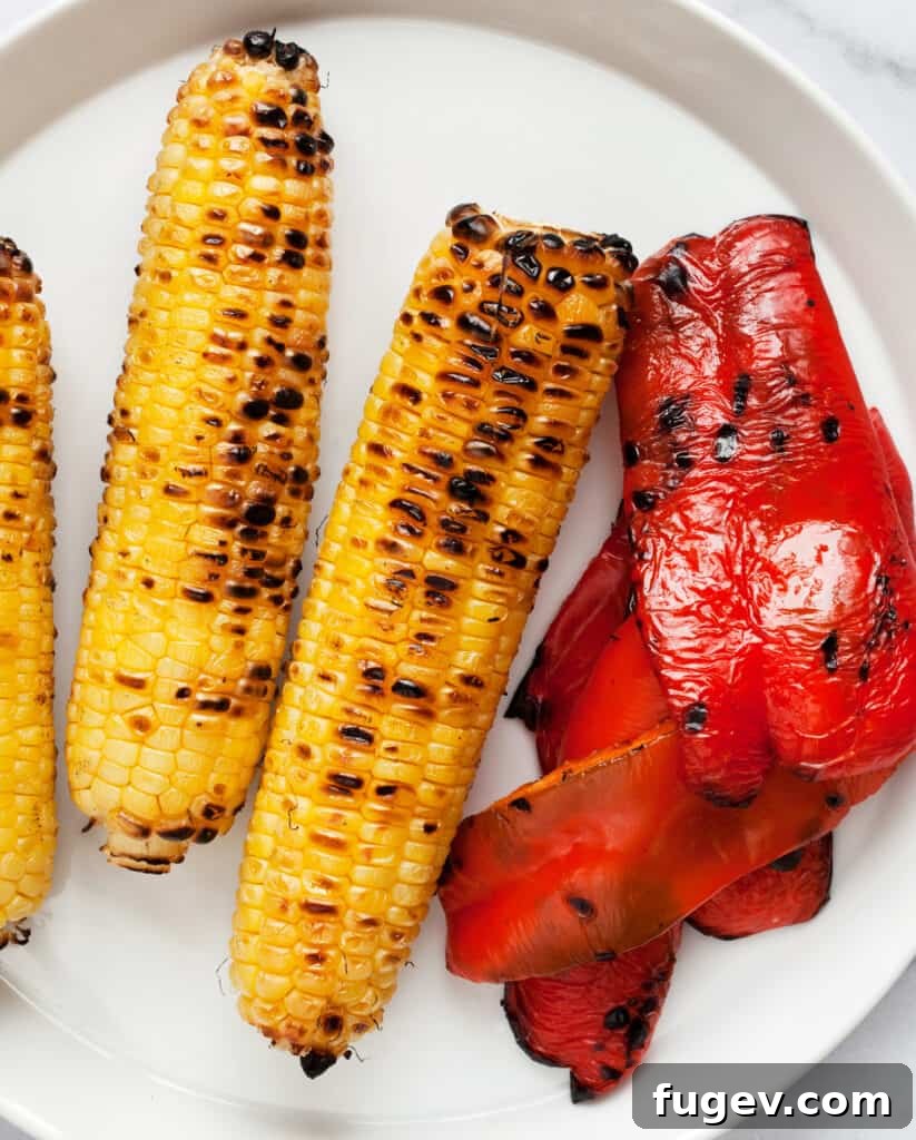 Grill-Kissed Corn and Pepper Kale Crunch 7 Grilled corn cobs and sliced red peppers on a grill grate