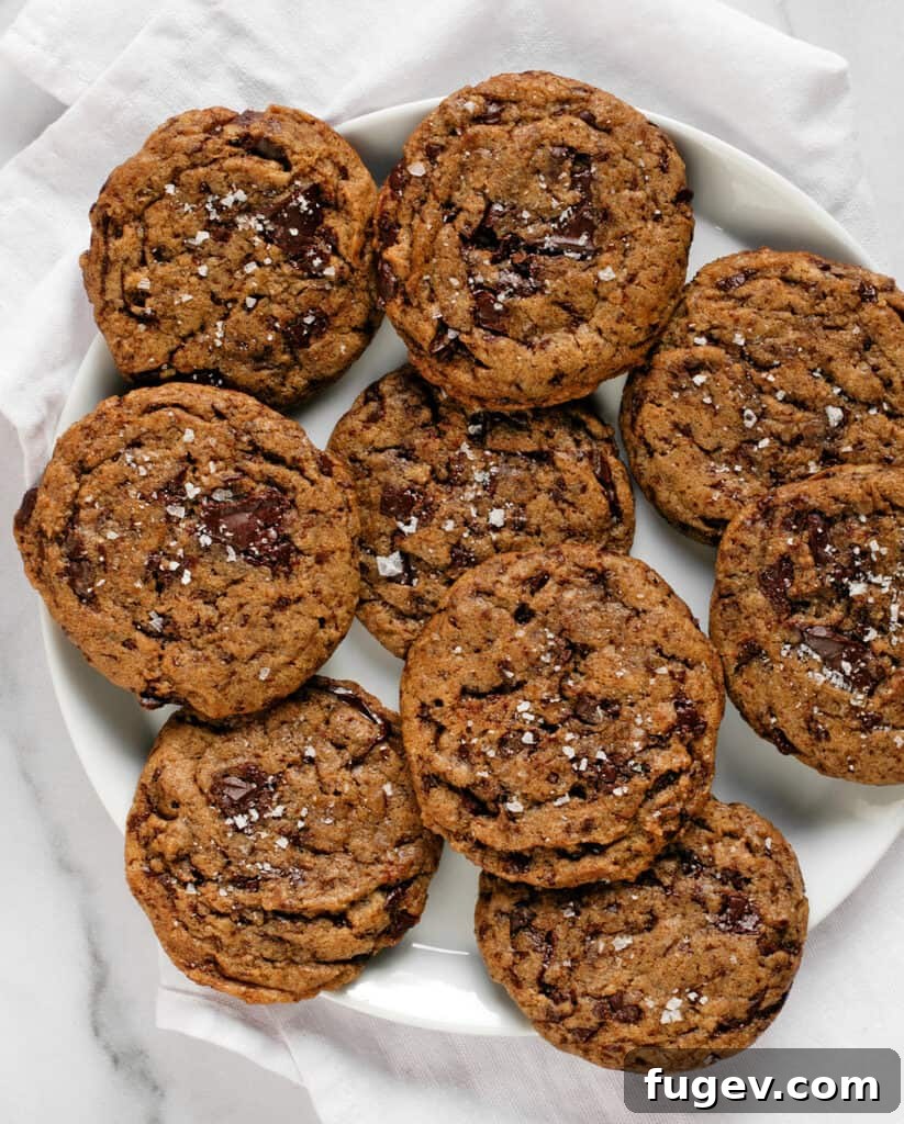 Cinnamon-Kissed Vegan Chocolate Chip Cookies 3 Vegan Cinnamon-Spiced Cookies cooling on a rack, showcasing their golden edges and delicious texture