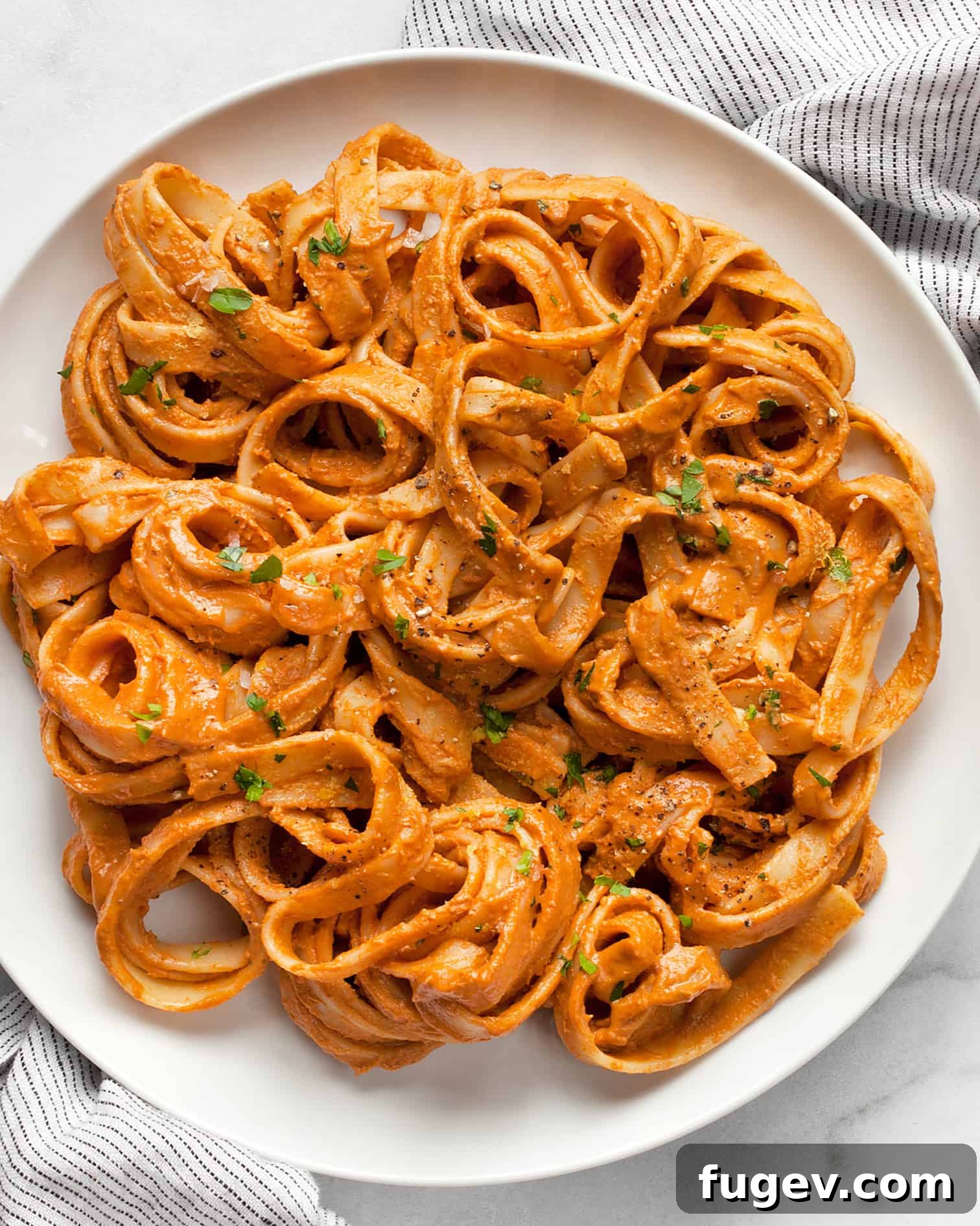 Velvety Vegan Tomato Spinach Pasta 9 A close-up of a serving of Creamy Tomato Vegan Pasta, garnished with fresh herbs