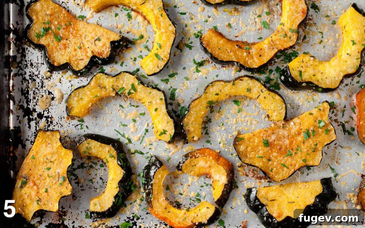 Golden Parmesan Roasted Acorn Squash 8 Roasted squash on a sheet pan sprinkled with fresh herbs.