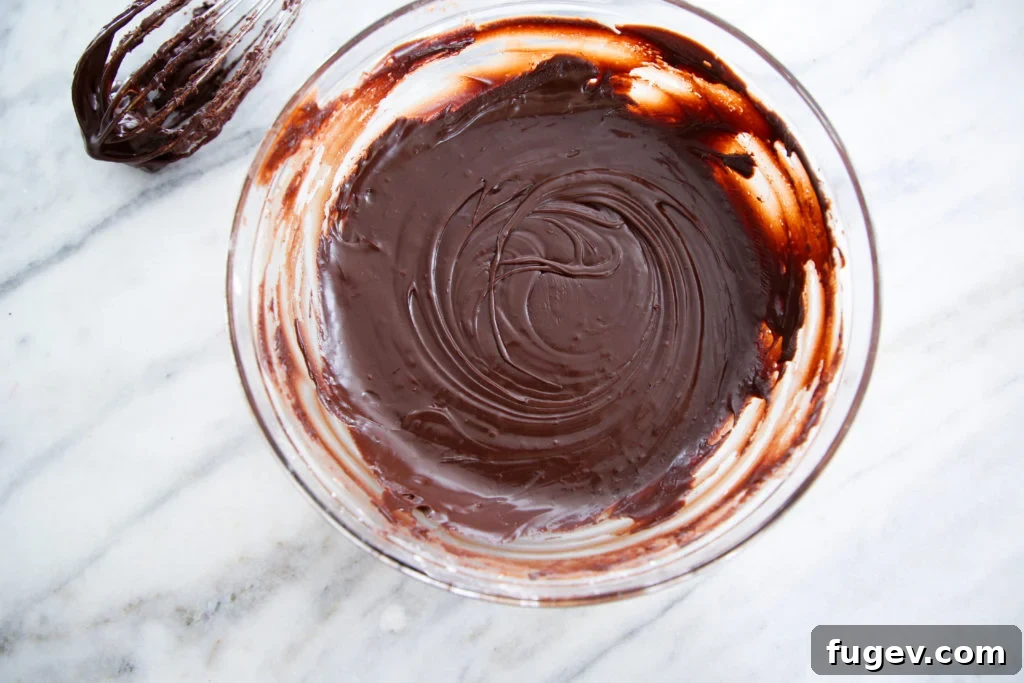 Decadent Fudge Drizzle 4 A bowl of glossy Chocolate Fudge Glaze with a spoon, inviting indulgence.
