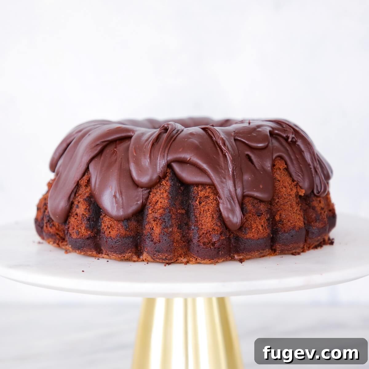 Secret Zucchini Chocolate Indulgence 4 A beautiful chocolate zucchini cake presented on a white and gold cake stand, ready to be served.