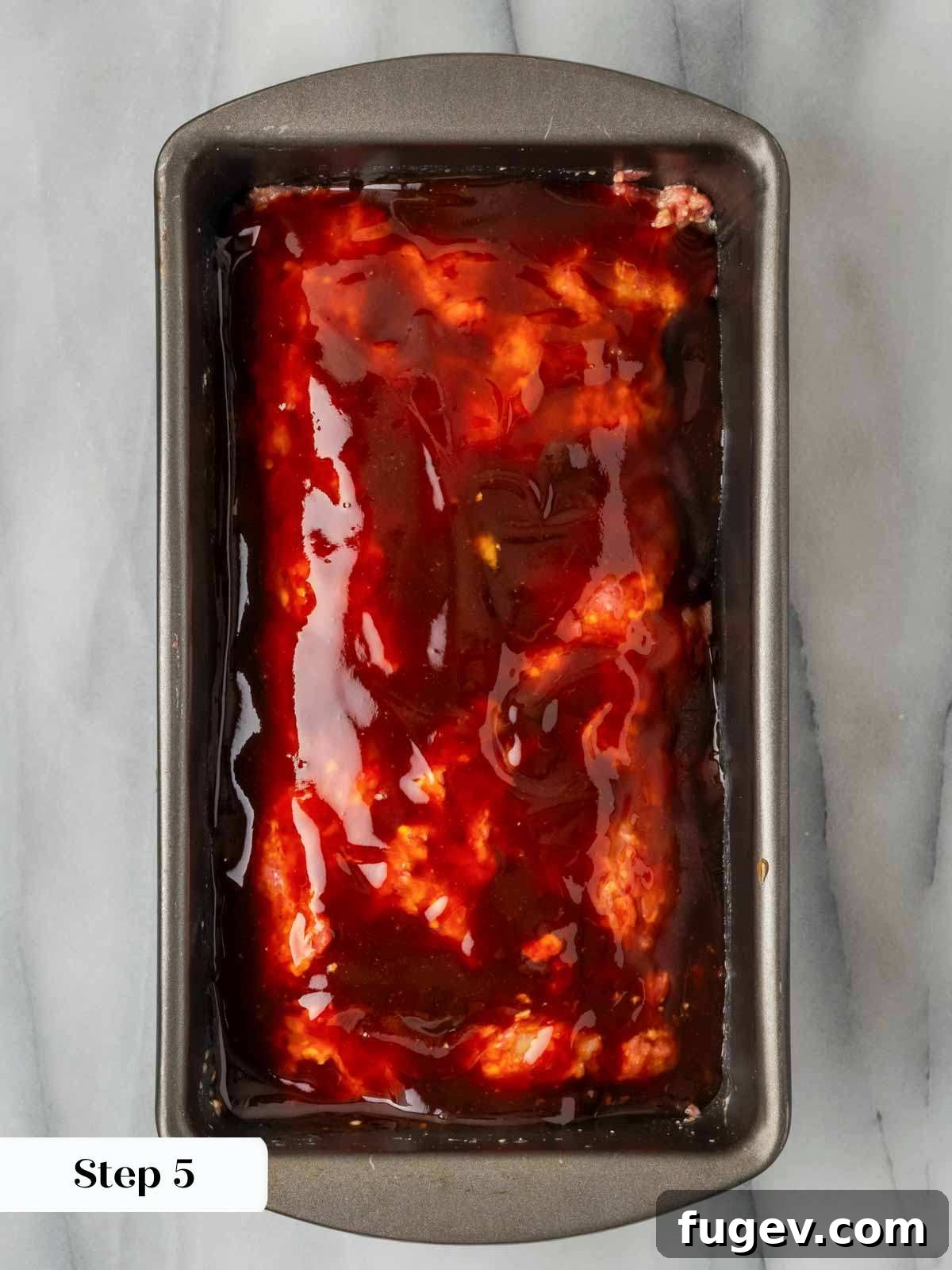 Sticky-Sweet Brown Sugar Meatloaf 7 Unbaked meatloaf generously coated with brown sugar glaze in a baking pan.