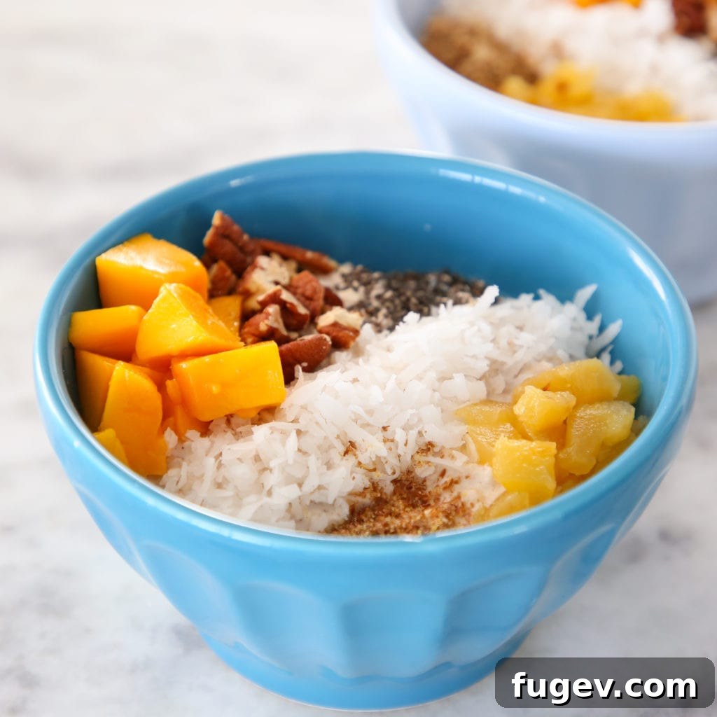 Island Oasis Overnight Oats 2 Tropical overnight oats in a glass jar, garnished with fresh fruit and coconut flakes.
