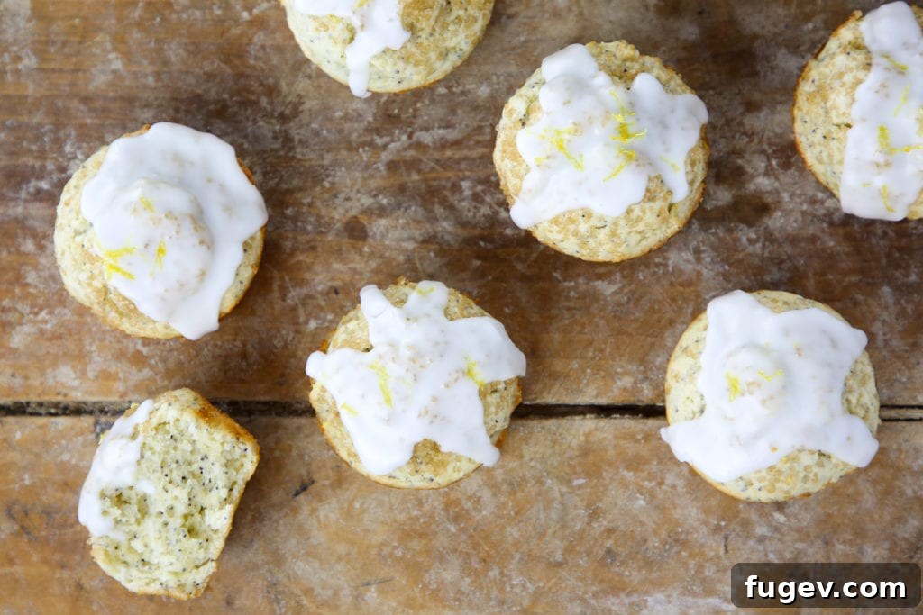 Zesty Lemon Poppyseed Muffins 4 Two Lemon Poppy Seed Muffins, one whole and one sliced open, showing the moist interior and poppy seeds