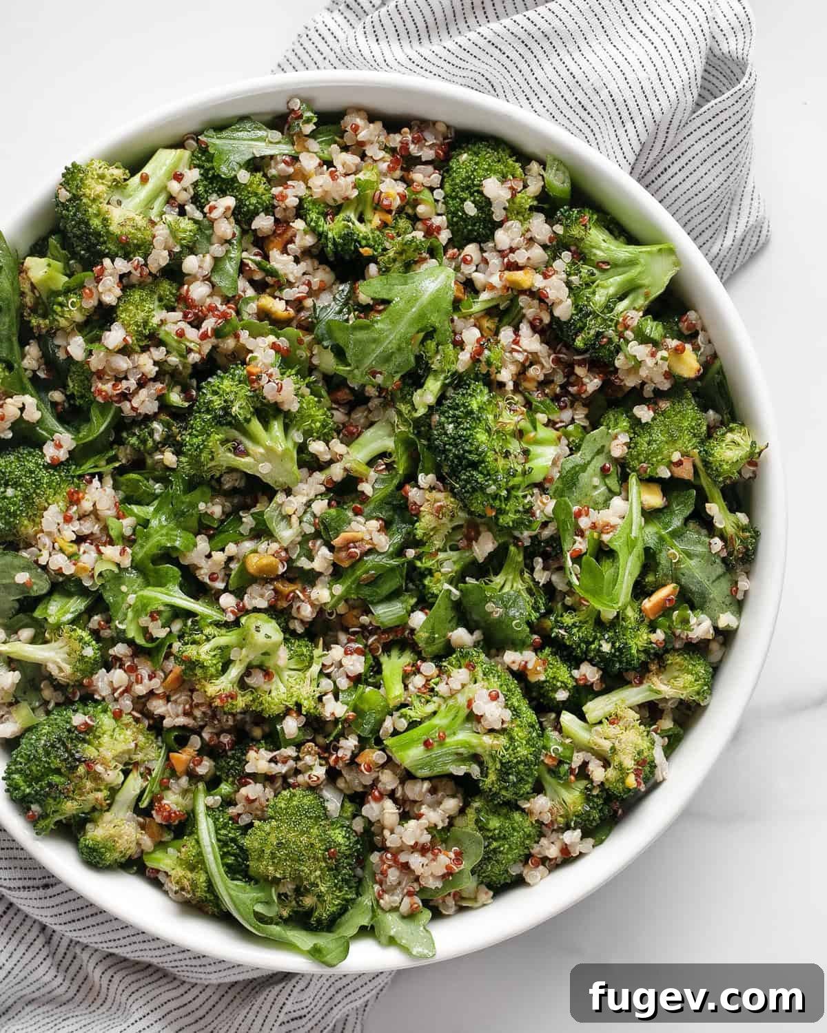 Vibrant Roasted Broccoli Quinoa Salad 2 A large bowl of roasted broccoli quinoa salad, showcasing its vibrant green and yellow colors, with a fork ready to serve.