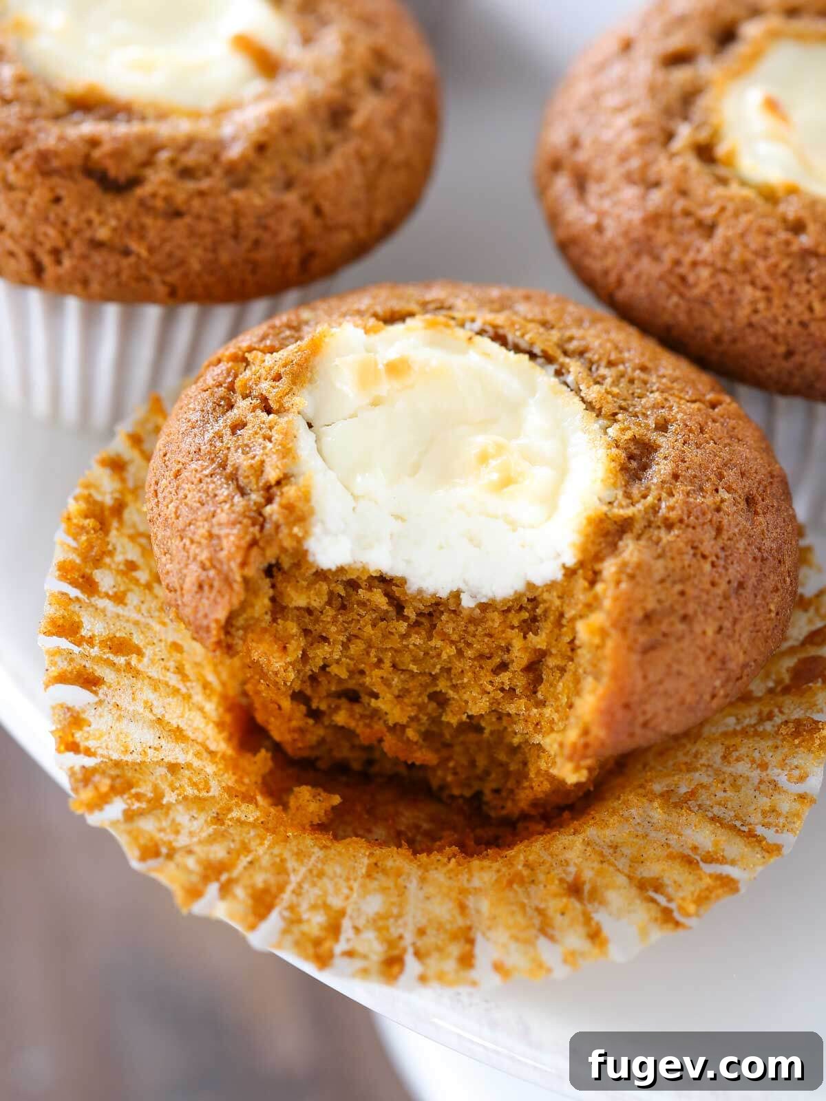 Swirled Pumpkin Cream Cheese Muffins 2 Delightful pumpkin cream cheese muffin, unwrapped and ready to eat, resting on an elegant cake stand.