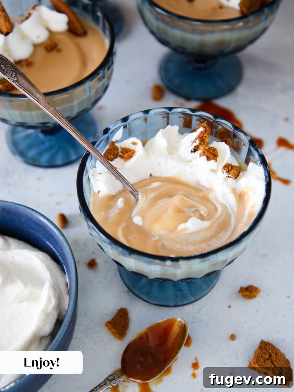 Decadent Caramel Pudding 8 A beautifully garnished caramel pudding in a glass coupe, topped with whipped cream and cookie crumbs, awaiting enjoyment.