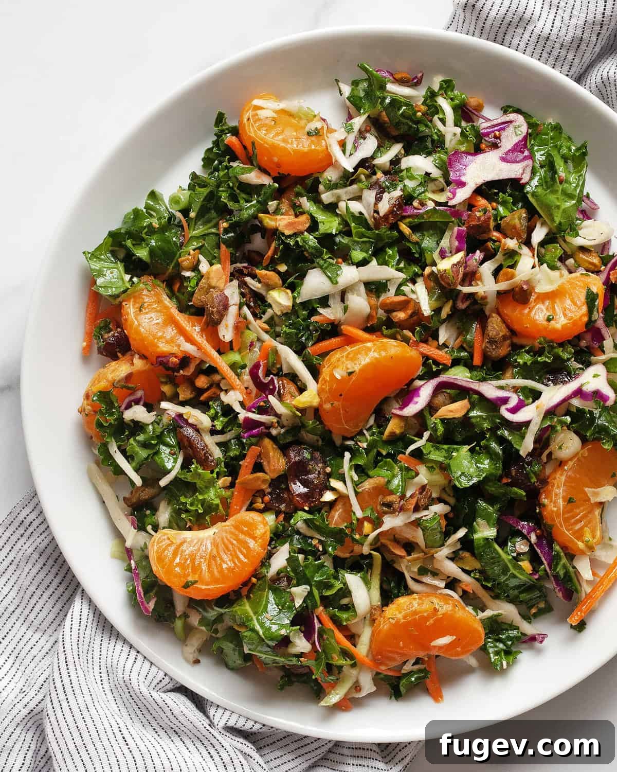 Zesty Mandarin Salad 6 A beautifully plated kale salad with vibrant mandarin oranges, green kale, and other colorful ingredients, ready to be eaten.