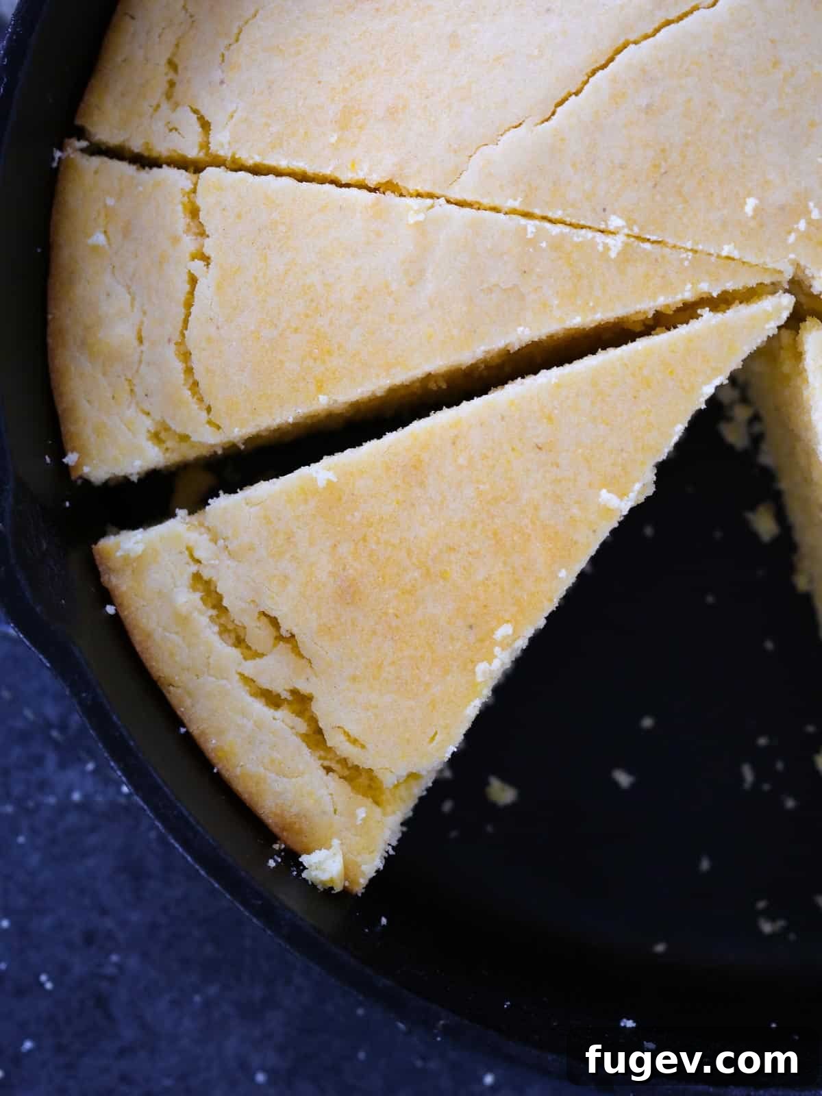 Southern Cornbread Perfection 2 Sliced savory Southern cornbread resting in a black cast iron skillet, showcasing its golden-brown crust and moist interior.