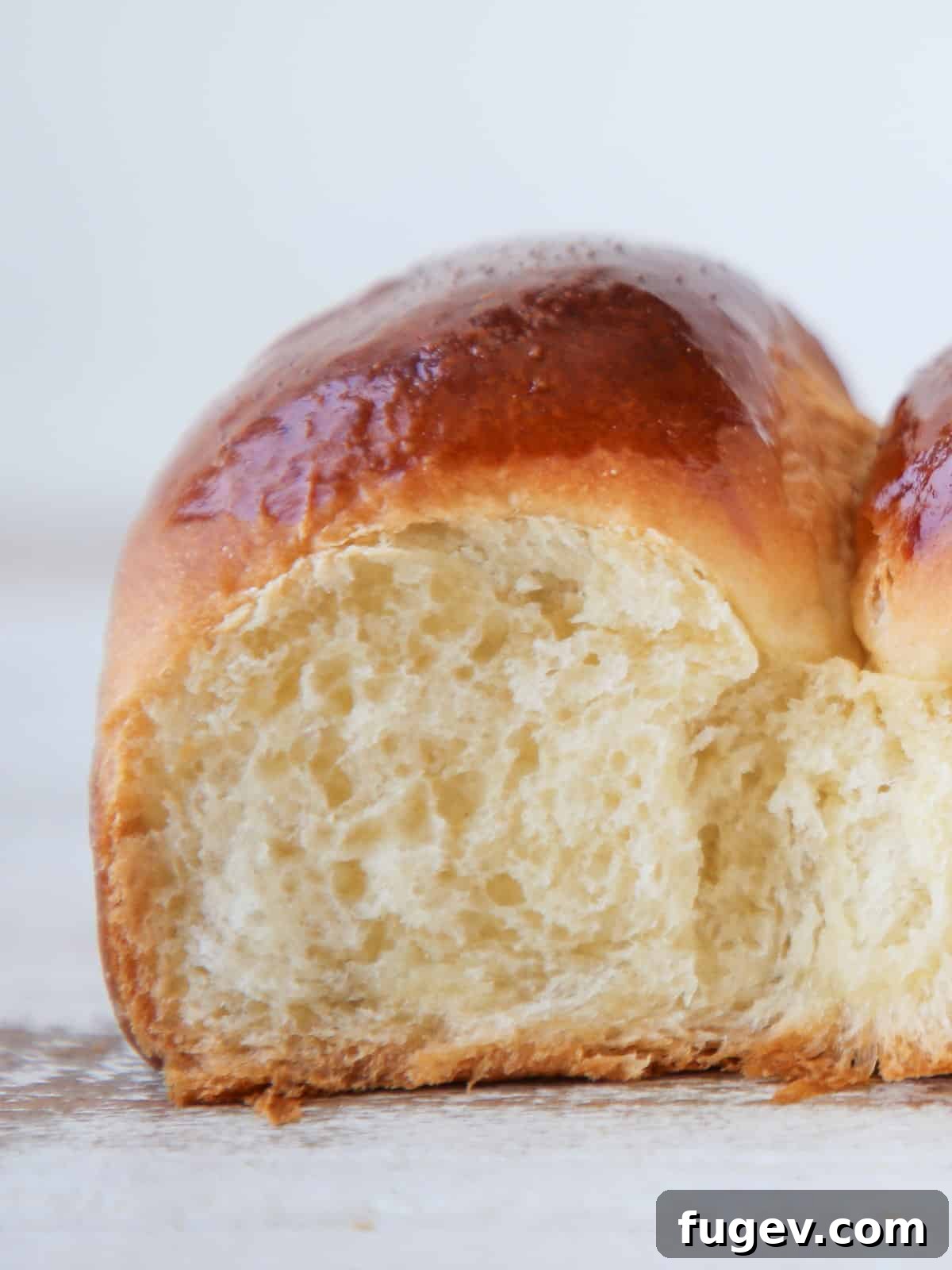 Pillowy Potato Rolls 7 Close-up of the soft, open crumb of a fluffy dinner roll, perfectly golden and tender on the inside.