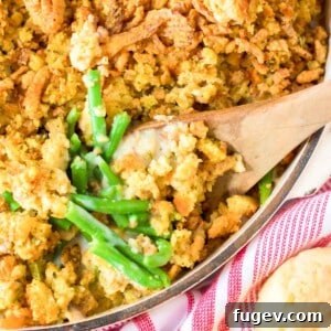 Green bean casserole with a wooden serving spoon, ready to be enjoyed.