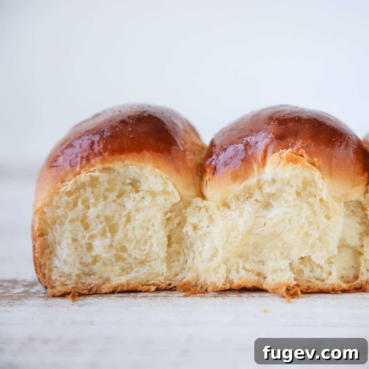 Classic Thanksgiving Dinner Recipes and Full Menu 14 Two soft and fluffy dinner rolls, showcasing their airy interior texture.