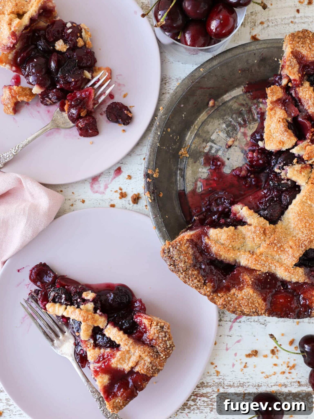 Classic Thanksgiving Dinner Recipes and Full Menu 16 A slice of vibrant cherry pie in a vintage pie tin, a classic Thanksgiving dessert.