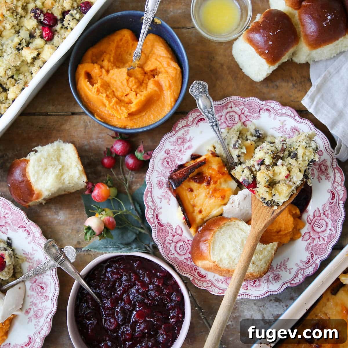 Classic Thanksgiving Dinner Recipes and Full Menu 3 Elegantly set Thanksgiving dinner tablescape with various dishes and autumnal decorations.