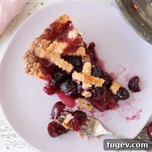 A slice of Cherry Pie with an almond crust and lattice top.