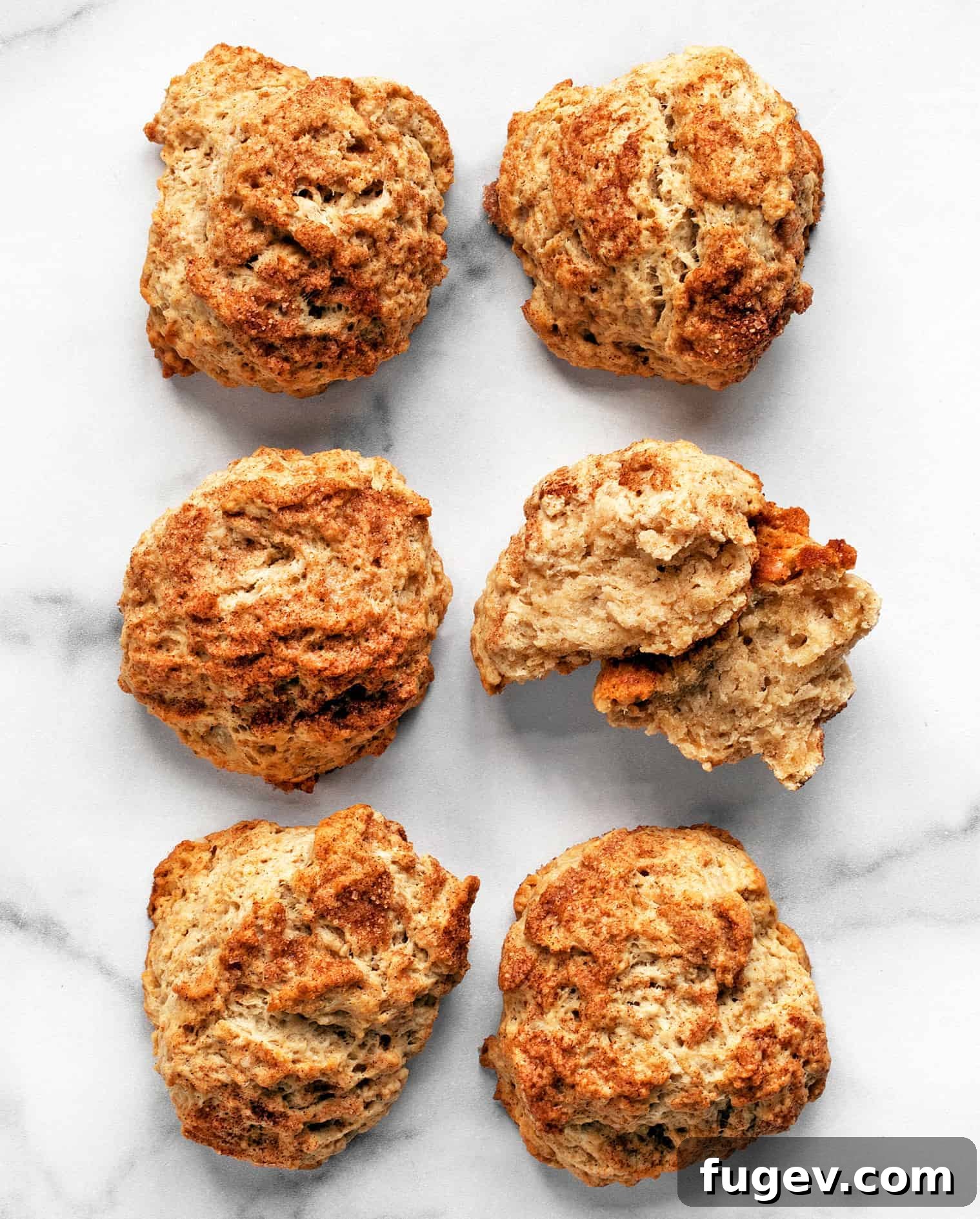 Cozy Cinnamon Scones 2 A close-up image of freshly baked Cinnamon Maple Scones, showcasing their golden-brown tops and rustic texture.