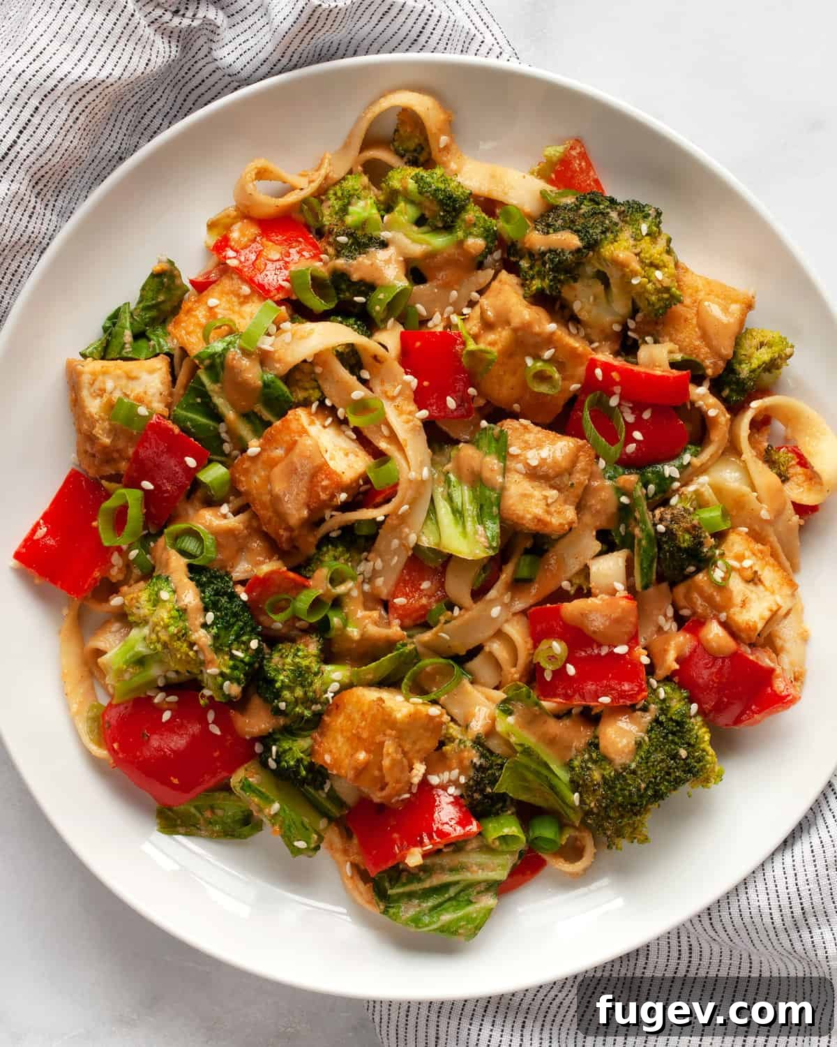 Creamy Peanut Tofu Veggie Stir-Fry 2 A vibrant plate of tofu vegetable stir-fry generously coated in creamy peanut sauce.
