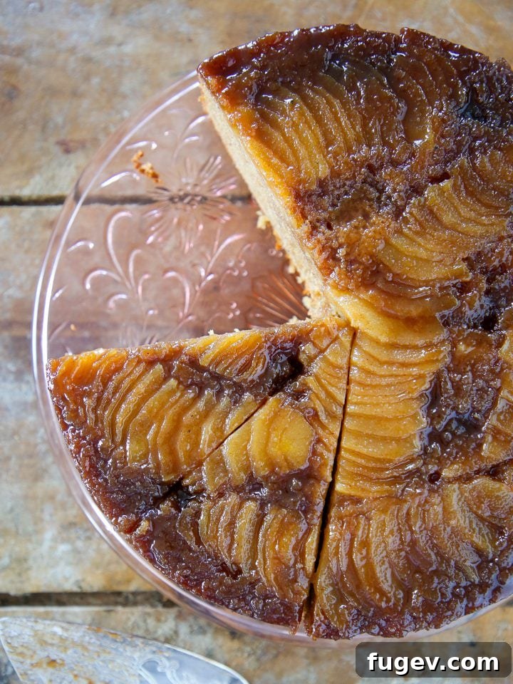 Caramelized Pear Delight 2 Pear upside down cake on clear cake stand, showcasing caramelized pears.