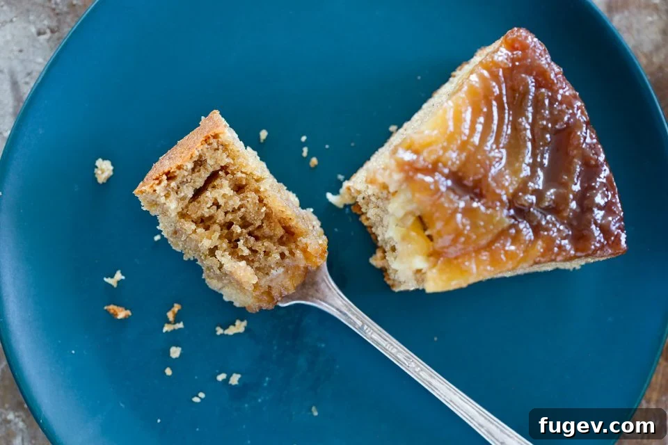 Caramelized Pear Delight 4 A perfectly sliced piece of Pear Upside Down Cake on a blue plate, revealing layers.