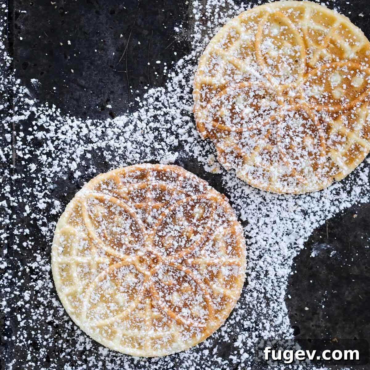 Sweet Italian Iron-Pressed Delights 5 Pizzelle cookies lightly dusted with powdered sugar, ready to be served.