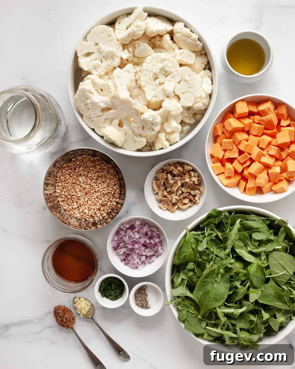 Roasted Sweet Potato & Cauliflower Salad 3 A selection of fresh ingredients for the roasted sweet potato cauliflower salad, including sweet potatoes, cauliflower, greens, red onions, walnuts, and vinaigrette components.
