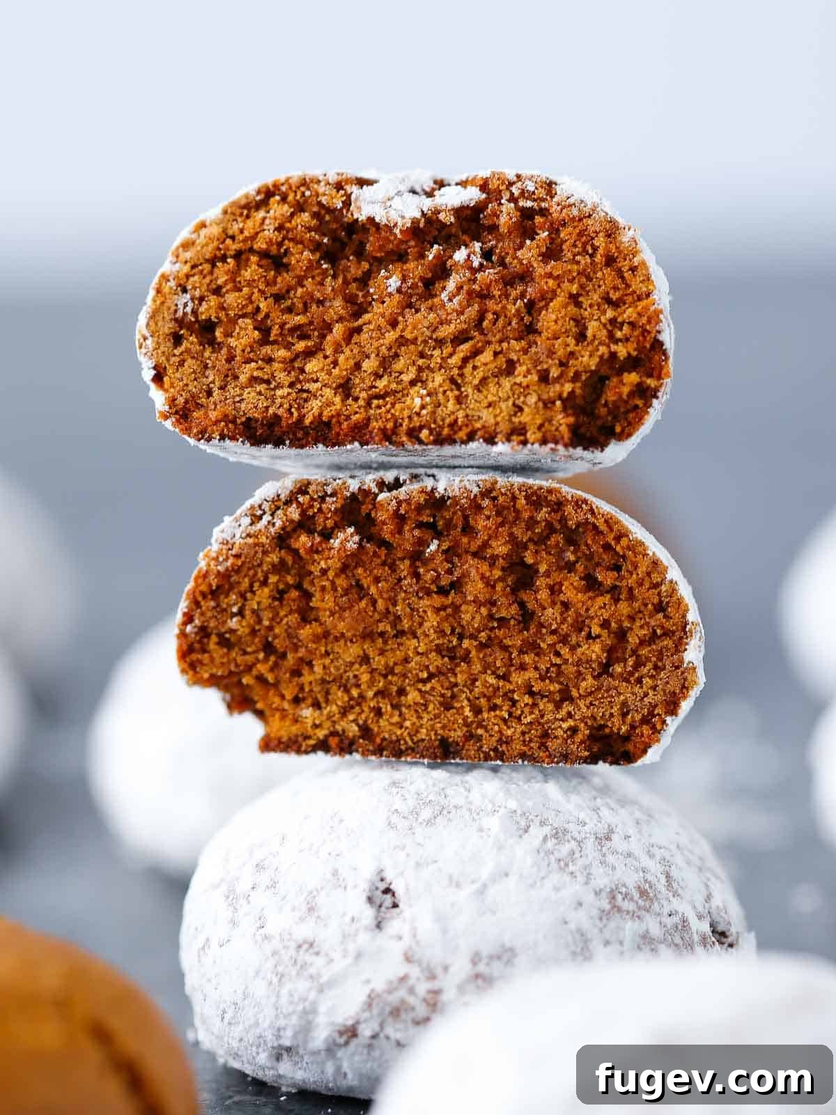 Holiday Spice Drops 2 three stacked Pfeffernusse cookies, coated in powdered sugar.