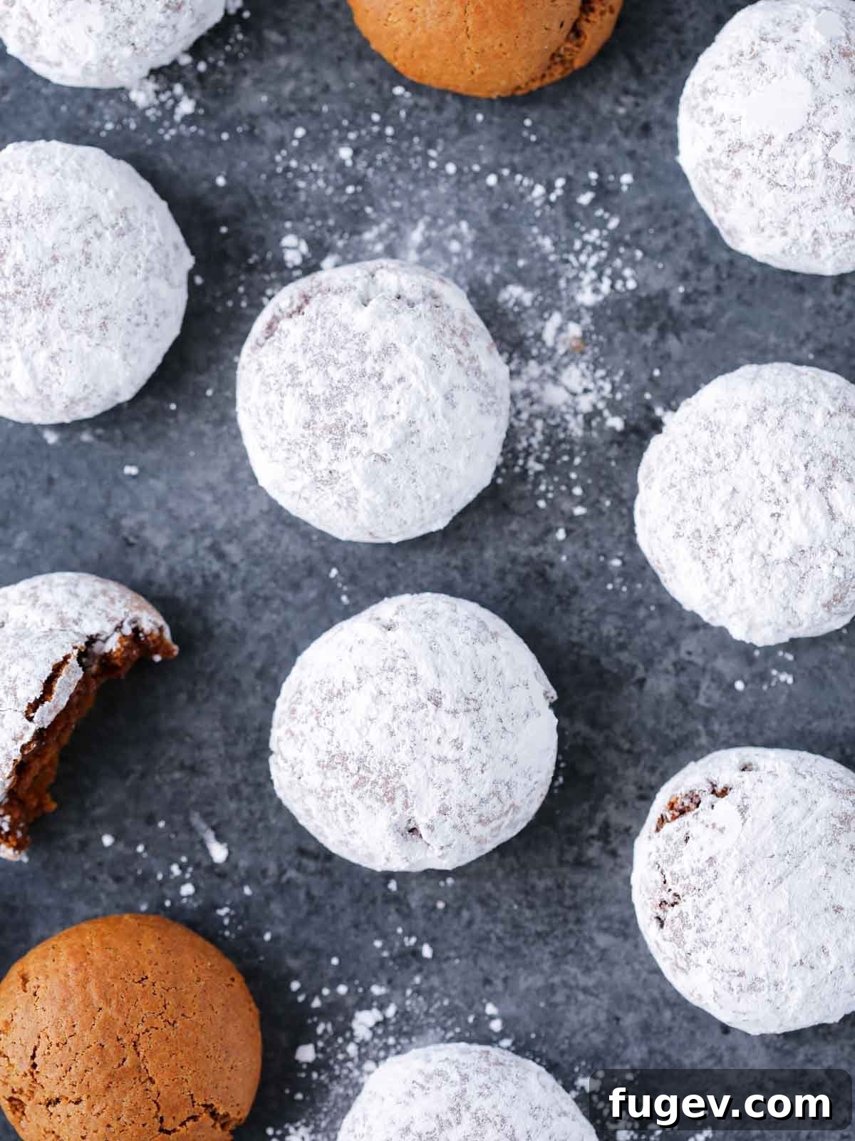Holiday Spice Drops 4 pfeffernusse powdered sugar coated on a grey surface, ready to be served.