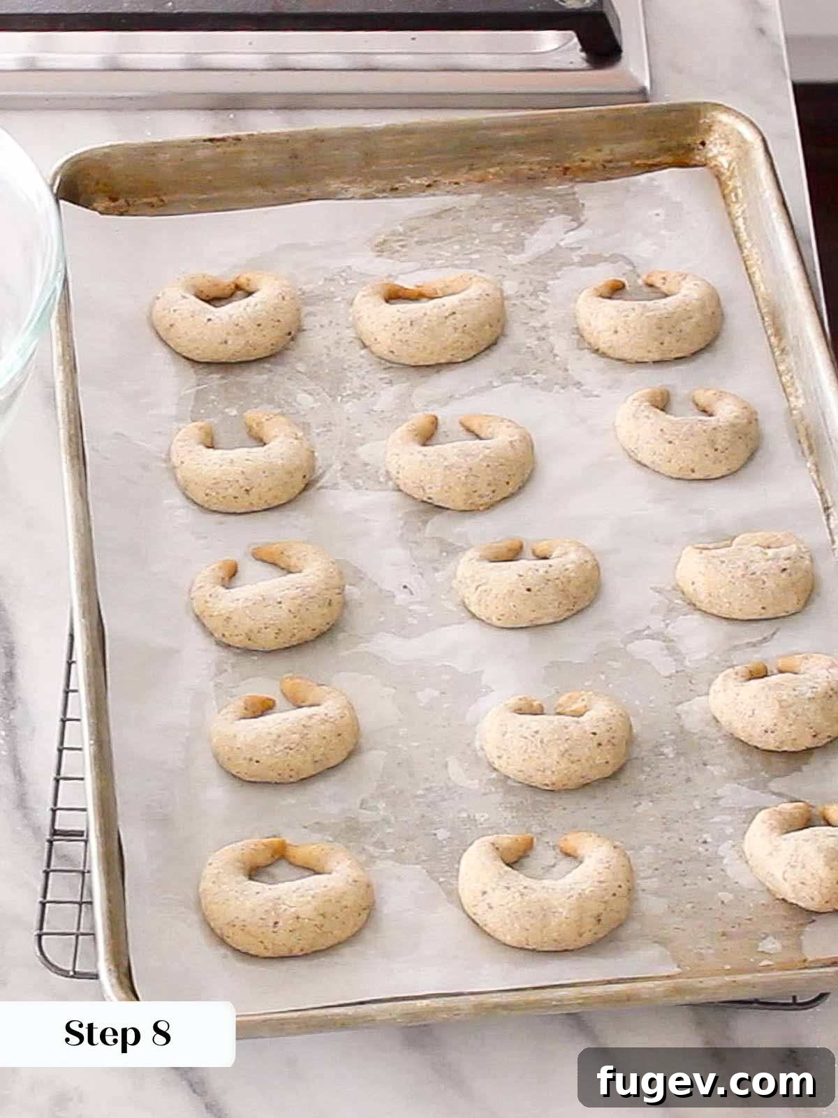Velvet Almond Crescents 10 baked crescent cookies on baking sheet.