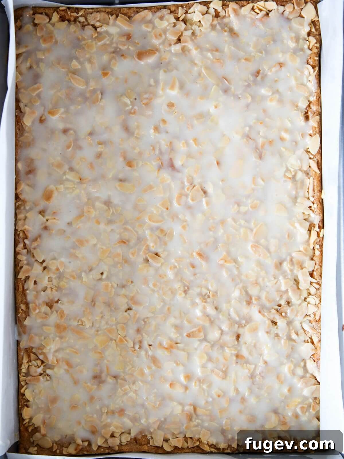 Golden Almond Squares 9 White glaze perfectly spread over a pan of cookies.