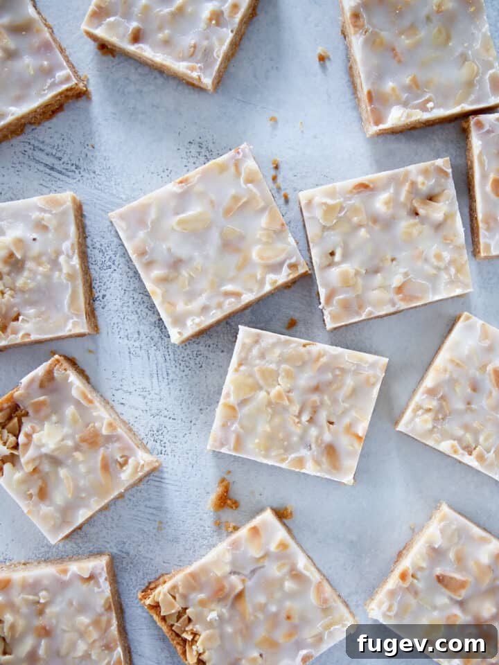 Golden Almond Squares 10 Sliced crispy almond square cookies over a light blue background.