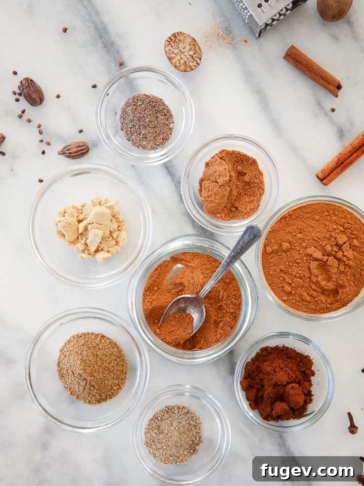 Homemade Speculoos Spice Blend 3 A small spoon scooping a portion of Speculoos Spice Mix from a wooden bowl, highlighting its fine texture and readiness for use.